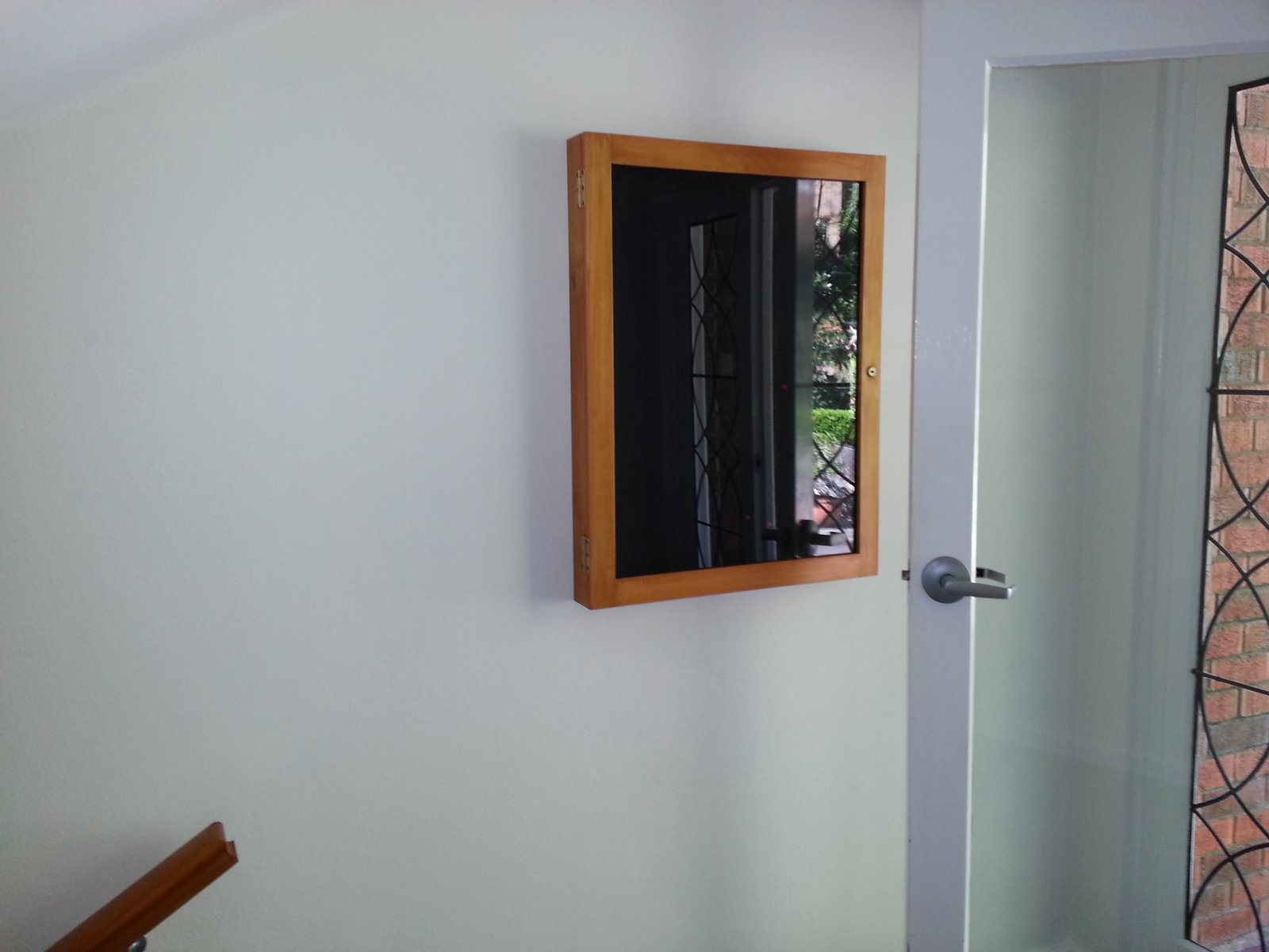 A custom timber-framed glass display case installed on a wall for a private client