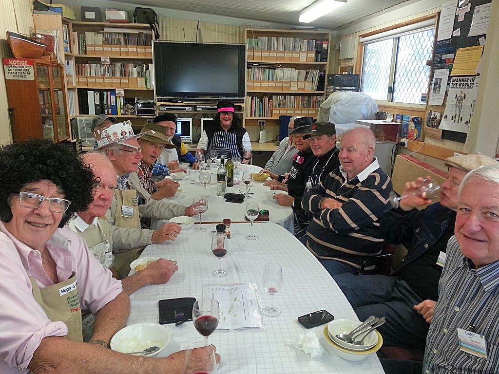 Shed members enjoying a cooking group lunch together, some in costume hats